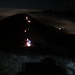 Dalla cima del Cornizzolo, uno sguardo verso le luci che evidenziano il Rifugio Marisa Consiglieri e quelle di alcune fiaccole che scendono dal Monte Rai. A destra le luci di Valmadrera.