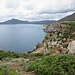 A destra delle rovine del Villaggio di Planu Sartu si vede la costa rocciosa che si estende in direzione di Buggerru, di cui si vede il molo frangiflutti del porto uscire verso il mare.