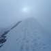 Die letzten Meter zum Gipfelkreuz, welches man im Nebel schon schwach erkennen kann.