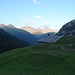 Rückblick über die Alp Sesvenna auf die Berge auf der anderen Talseite im Sonnenlicht