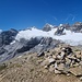 Gipfelsteinmannli auf dem Hinter Geissbützistock. In Bildmitte rechts ein Niederschlags-Messgerät von Meteo Schweiz