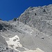 Die Gletschermulde des einstigen Watzmanngletschers.  Gegenüber am oberen Ende des Schuttfelds kann man die steil nach oben rechts ziehende Rinne erahnen die den Einstieg in die Route vermittelt.