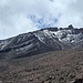 Blick vom Refugio Carell auf die Castillo-Route. Die Route verläuft im Schnee unterhalb der Felswand.
