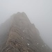 Im Nebel geht es über einen ausgesetzten verwitterten Schiefergrat (runde Formen) Richtung Gipfel.