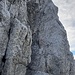 Der kreuzgeschmückte Felszahn des Tuxeck wird über eine ca. 10 Meter hohe senkrechte Wand mit einigen fest einbetonierten Eisengriffen erreicht (II-III)