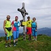 vier farbenfroh gekleidete Gipfelbesucher