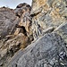 Kurze Kletterpartie nach dem Felsspalt auf dem Weg zur Grube II. Entlang dem gelben Seil (rechts sichtbar) etwas abdrängend zum Busch, dann über eine senkrechte Felsstufe ca. 4m hinauf (T5, III, Foto 2023)