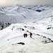 Abstieg zu Fuss zurück zum Skidepot unterm Gipfelgrat des Winterhorns. Blick Richtung des tief verschneiten Gotthardpass. Und der Staub erfüllt die ganze Atmossphäre...