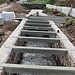 Grabenrohbau<br />Die Steine der historischen Grabenmauern werden neu mit Magerbeton aufgesetzt, die Betonbalken tragen später die Plattenabdeckung.