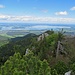 Blick vom Gipfel zum Friedenrath-Kreuz, dahinter der Chiemsee