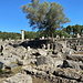 Olympia (Ολυμπία) - Blick zum Zeustempel. Vorn sind unterschiedliche Bauteile, wie Kapitelle, Steine u. s. w. zu erkennen.