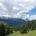 Unterhalb sieht man ein Stück der Straße nach Gschwandt, im Hintergrund der Wetterstein in Wolken.