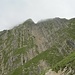 Zeitweise verdecken ein paar Nebelwolken den Gipfel. Vor dem gegenüber sichtbaren Anstiegsweg geht es gleich noch durch eine Senke mit Kletterstelle.
