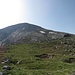 Auf unerwartete Weise ist dieser Sattel ein liebliches Wiesenkleinod; darüber lockt die Kuppe des Monte Tae.  Der Anstieg ist weniger lang, als man meint: es geht komplikationslos über den Schrofenhang in einer Rechts-Links-Schleife hinauf.