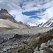 Augenschein der 3. Etappe Richtung 3. Camp Khuispang (hinter der dunkelbraunen und hellgrauen Moräne) beim Übergang auf den Gondogorogletscher: zuhinterst links sieht man die besonnte Firnflanke unter dem Gondogora La, während der Laila Peak (rechts oben ausserhalb des Bilds) in Wolken gehüllt ist