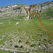 Blick von der Strasse oberhalb P. 1675 hinauf zum Doppelcouloir: der Zustieg führt durch eine bequeme Geröllrinne, die eigentliche Route dann kurz durch deren Fortsetzung, über das darüber liegende Grasband nach links, durch das rechte Couloir hinauf, und darüber unter den oberen Felsen schräg hoch nach rechts