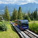 Standseilbahn Gubałówka - Ausblick an der Bergstation, die gerade Wagen 1 verlassen hat. Hinten sind Teile der Hohen Tatra (links) und die Westliche Tatra (rechts) zu erahnen. Unten im Tal liegt Zakopane.