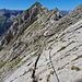 Darauf folgende Platten werden mit Hilfe der nächsten Seile überwunden, dazu folgt man zuerst einem kleinen, leicht abfallenden Riss....
