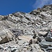 Genau dort, wo das Schneefeld endet, zeigen rote Markierungen auf den Felsen den weiteren Weg an.