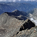 Abstieg über den oberen Chli Dirruhorn NNW-Grat unterhalb P. 3815: unten das Galenjoch, links die Gugla, dahinter u.a. Breithorn und Mittelberg, darüber markant u.a. das Steital- und das Schwarzhorn, in den Wolken die westlichen Berner Alpen, und rechts unten der untere Riedgletscher mit seinen Moränen