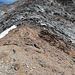 Blick von der flachen Passage auf ca. 3450m. Man sieht oben etwas rechts der Bildmitte die rötlichen Platten. Über diese kann der dunkle Kopf des Aufschwungs (steil, extrem brüchig, keine Sicherungsmöglichkeiten) umgangen werden.