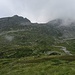 a sx il Vigon, in mezzo il ripiano da salire e il passo, verso dx il Piz de Mucia avvolto dalle nuvole