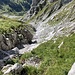 Blick auf den Gegenhang, wo die Rinne gequert werden muss (Steinmann im Gras, Standort vorheriges Bild).