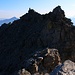 Piz Forbesch Nordostgrat:<br /><br />Rückblick zum Gratgipflel P.3176m mit seinem grossen Steinmann. Man beginnt die Traverse auf der schattigen Nordseite darunter auf halber Höhe zum flachen Gratteil mit dem kleinen sonnenbeschienen Felstürmchen. Mein Fehler war, dass ich bei diesem Türmchen schon mit der Querung wegen begann und so in schwieriges Gelände gelangte mit viel losem Schutt und Fels.