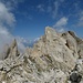 Hinter der Hütte erkenne ich mein nächstes Ziel in Form der Cima di Valsorda (Schreppwand): etwa rechts der Bildmitte sieht man das steile Geröllkar, welches durch einen schiefen Turm (mit Schattenwurf) in zwei Teile getrennt ist.<br />Ich bin versehentlich rechts des Turmes aufgestiegen: das geht zwar, ist aber noch steiler als die linke Seite. Links des Turmes geht es leidlich "gut".
