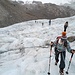 Gessica im Vordergrund als Erste der Seilschaft auf dem flachen und wenig spaltenreichen Grenzgletscher, der zur Orientierung mit Markierungsstangen versehen ist. 