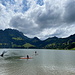 Am Schwarzsee - Das Gewässer zeigt sich in diesem Augenblick tatsächlich ziemlich dunkel und scheint auch von Walen, Nessis oder deren Verwandtschaft bevölkert zu sein. Neben zahlreichen Besuchern, die am Strand ausharren, wagen sich Mutige dennoch ins Wasser...