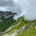 Im Aufstieg zum Kaiseregg - Rückblick unweit des Kaisereggpasses, während die Wolken über den Kamm schwappen. Links ist der Schafberg zu sehen.