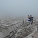 Trotz Regen, Graupelschauer und extremen Windböen kämpfen wir uns bis in die rechte Flanke des Schneegipfels. Dort war dann aber Schluss, als auch der Bergführer ins Wanken kam. Ein Begehen des Grates zum Kreuz war mit der großen Gruppe für ihn und uns lebensgefährlich. Im Bild sind wir bereits auf dem Rückzug. Die Regenhüllen hat es allen von den Rücksäcken gerissen.