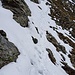 Dieses und die folgenden Fotos habe ich erst beim Abstieg gemacht.<br />Die Schlüsselstelle: steile Schneefelder bedecken den markierten Weg, insbesondere die ersten paar Meter. Als ich den Fuss des Felsens erreiche, der von der linken oberen Ecke herunterzieht, gehe ich direkt an seinem Rand auf dem Schneefeld weiter um die Ecke …