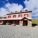 <b>Alle 10:00 pervengo al Rifugio Pizzini-Fràttola (2706 m), esattamente come cinque giorni fa. Il sole splendente, le cime con la leggera sbiancata della notte, ovattate da lembi di nebbia evanescente, rendono il paesaggio particolarmente seducente.</b>