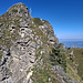 Blick vom Mittelgipfel entlang dem einfachen SE-Grat zum Hauptgipfel, dahinter der N Vorgipfel mit dem Kreuz, links unten der Schlusskamin