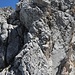 Schlüsselstelle I, wir klettern auf der Kante zu dem überhängenden Block oben. Umgehung links durch die schattige Rinne möglich.