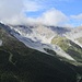 Rocce calcaree che dalla cima dell'Ortles scendono verso la cima Tabaretta e il rifugio Payer coperti dalle nuvole. 