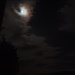 la luna di notte che comincia a farsi strada tra le nuvole