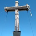 Das große Gipfelkreuz mit einem kleinen Gartenzwerg als Wächter. 