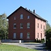 Baruth, Bahnhofsgebäude<br />Baruth lag an der Bahnstrecke Löbau - Radibor. 1972 wurde der durchgehende Betrieb nach Löbau eingestellt. Baruth war fortan Endpunkt der nur noch im Güterverkehr betriebenen Strecke von Radibor. Die in Baruth angebundene 4,4 km lange Werkbahn nach Kleinsaubernitz wurde nach Einstellung der Kohleförderung und des Restgüterverkehrs 1945 bis zum Schamottewerk Neudörfel zurückgezogen. Später erfolgte noch einmal ein Neuanschluss eines geheimen NVA-Depots am km 3,5. Mit der Wende wurde die Werkbahn rasch abgebaut. Die Strecke nach Radibor wurde ab 1996 stückweise stillgelegt und ab 2004 abgebaut.