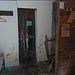 atrio che si trovo all'entrata del rifugio, a destra vi è la legnaia interna (bisogna procurarsela) separata dall'appendi abiti e la scala che conduce al dormitorio