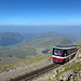 Snowdon / Yr Wyddfa - Während hinten Llyn Cwellyn und Mynydd Mawr (698 m) zu sehen sind, fahren Lok 11 (Peris) und Wagen 16 talwärts. Dieser ist übrigens nach Dame Shirley Bassey benannt, die aus Wales stammt.