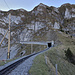 Dem Gleis entlang von La Perche zur MOB-Galerie: rechts oberhalb der Grasrücken, darüber in der Mitte die avisierte Route zu P. 2022. Links davon die Voie des Pare-Avalanches (C. und Y. Remy, 1979) mit dem unteren Grasband als Zustiegsvariante, rechts davon das Couloir Central (C. und Y. Remy, 1978), und ganz rechts oben der kleine Pfeiler (M. Zosi, 1966)