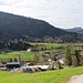 Parkplatz fast erreicht. Bioenergiekraftwerk mit Schornstein im Vordergrund, hinten das Annakircherl. Ich bin über die Wiese hinuntergequert um rechts vom Kraftwerk den Parkplatz anzusteuern.