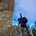 Helme auf, Gurte angelegt, und ein paar Exen drangehängt; das metallische Geklapper gibt Sicherheit. Der Start auf den Grat ist an einem Durchlass rechts vom Bergfried. Man verlässt die Burganlage, klettert links schon ein bissl ausgesetzt eine Felsrippe hinauf zu einem schmalen, ausgesetzten Band in der Nordseite des Turms. 