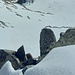 Tiefblick vom Gipfelgrat in die Aufstiegsflanke. Beim grünen Pfeil führt der unterste Schneehang nach unten.