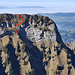 Blick vom Grat zwischen P. 1942 und 1951 der Sibe Hängste zurück zur Schörizflue E-Flanke: rechts die Schulter ca. 1780m, nach links das Gras- und Schrofenband unter den Flühen von der 1. zur 2. Rippe, rot die Aufstiegsroute mit den 3 Felsstufen zum N-Grat zwischen Schörizflue N- (rechts) und Hauptgipfel (links). Dahinter über dem Schwarzenburgerland der Waadtländer Jura