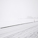 Schneebedeckte Strasse ausgangs Kleinwabern. Das Anwesen Nessleren ist im dichten Schneetreiben nur schemenhaft zu erkennen.