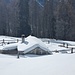 Eingeschneite Hütte am Weg
